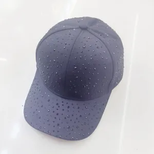 Detailed top view of black baseball cap with sparkling rhinestones on canvas fabric