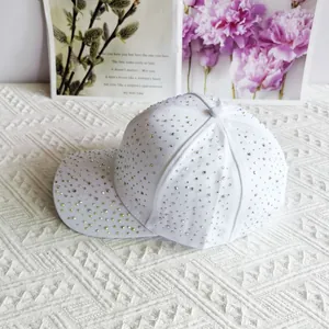 Close-up of sparkling iridescent rhinestones on a white canvas baseball cap