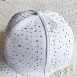 Close-up of white baseball cap with full iridescent rhinestone embellishment and crown