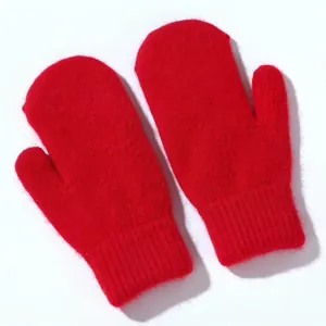 Dettaglio di muffole in lana d'angora rossa con morbida consistenza e polsini a costine