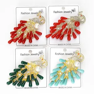 Detail of elegant peacock brooches featuring colorful rhinestones and pearls on gold base