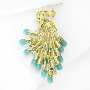 Elegant gold-tone peacock brooch with turquoise stones and secure safety pin closure