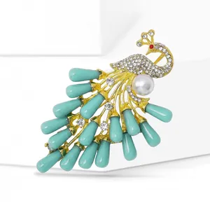 Detail of elegant peacock brooch with crystal rhinestones and blue teardrop beads