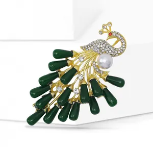 Macro shot of peacock brooch with white pearls and emerald green feathers detail