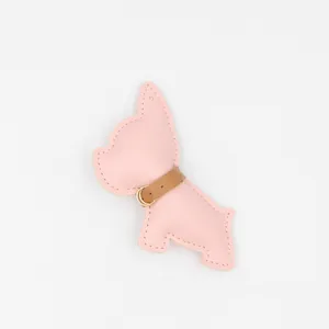 Dettaglio del portachiavi bulldog in pelle rosa con cuciture e fibbia dorata