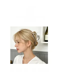 Close-up of transparent acrylic heart hair claw clip on blonde hair showing secure grip