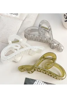 Detailed view of heart-shaped vintage hair claws in grey, cream, and olive green