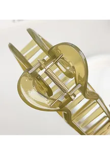 Detail of olive green translucent hair claw clip with heart-shaped curve design