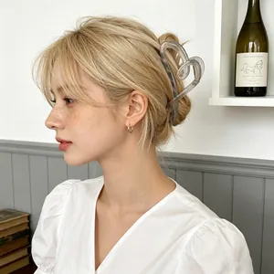 Elegant heart-shaped hair claw clip in transparent grey worn by a female model
