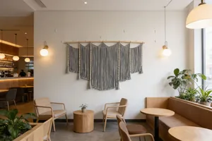 Detail of grey macrame wall hanging with wooden beads and hand-woven cotton fringe