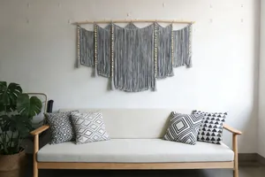 Detailed macro view of large handmade macrame wall hanging with grey cotton tassels