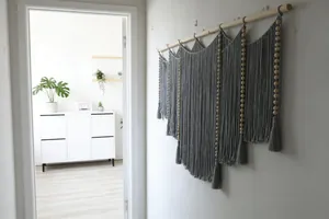 Close-up of Bohemian hand-woven gray cotton tapestry with wooden beads and tassels