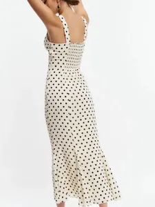 Back view of white polka dot midi dress with smocking detail and mermaid hemline