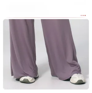 Detail shot of draped wide leg trousers in dusty pink showing fabric and hem