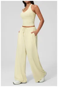 Detail of high-waisted lemon yellow wide-leg trousers with adjustable drawstring waist