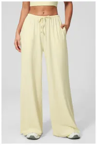 Detail of light yellow wide-leg lounge pants with adjustable drawstring elastic waist