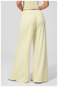 Macro detail of high-waist elastic waistband and soft brushed fabric on yellow trousers