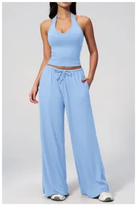 Detail of high waist drawstring waistband and side pocket on blue wide-leg trousers