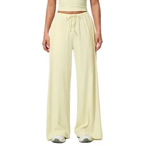 Women's light yellow wide-leg sweatpants with elastic drawstring waist and drape fit