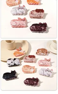 Detail of cute acetate cat and corgi dog hair claws with marble texture and pearly finish