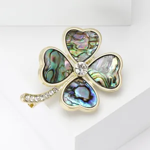 Elegante spilla a quadrifoglio dorata con conchiglia abalone colorata e strass luce