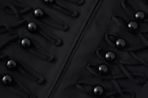 Dettaglio ravvicinato dei bottoni vintage doppiopetto su un cappotto nero