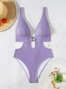 Detailed flat lay of lavender ribbed one-piece swimsuit with chic gold ring and side cutouts