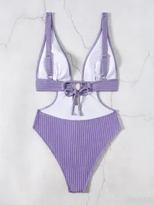 Detail of purple ribbed monokini featuring deep V-neck, waist cut-outs and ring buckle