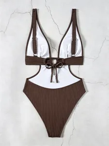 Detail of dark brown ribbed one-piece swimsuit with white panels and ring tie detail