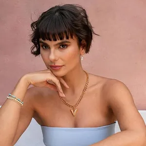 Detailed view of 14K gold cuban chain necklace with a sharp cone pendant on model