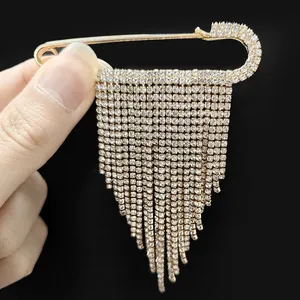 Detail of luxury gold tassel pin brooch with sparkling diamonds and elegant fringe