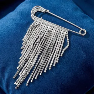 Detailed view of silver safety pin brooch with sparkling rhinestone fringe tassels