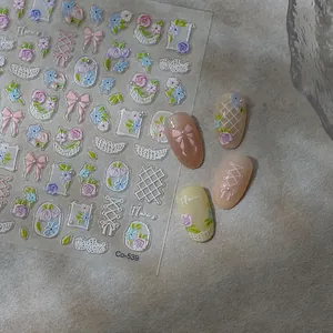 Close-up of 3D embossed nail art stickers with pink bows and delicate flower patterns