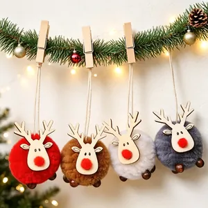 Set of four felt reindeer ornaments with wood details hanging from a pine branch