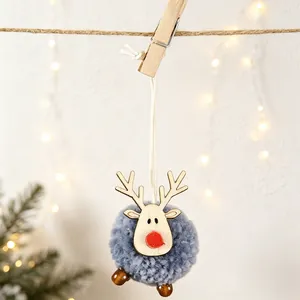 Close-up of a blue felt ball reindeer ornament with wood antlers on a holiday string