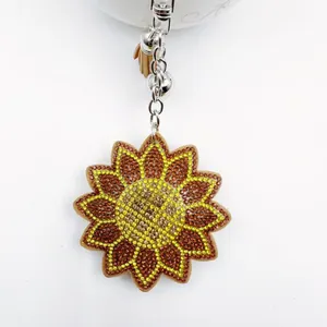 Porte-clés tournesol étincelant avec strass jaunes et pompon en cuir sur fermoir argent