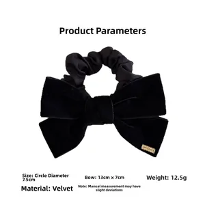Detailed view of black velvet bow hair scrunchie with dimensions 13x7cm and brand tag