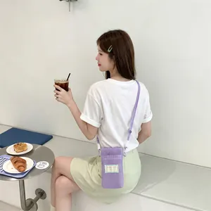Detail of purple mesh phone bag with adjustable strap in a cozy cafe setting