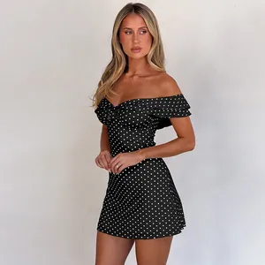 Close-up of the front knot detail on the off-shoulder black and white polka dot dress