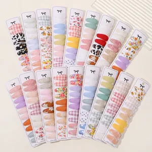 Assorted fabric covered snap hair clips with floral, plaid, and leopard patterns