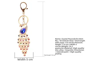 Close-up of crystal peacock keychain with blue gemstone and colorful rhinestones