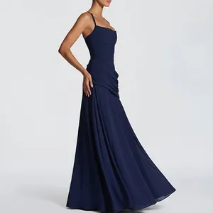 Close-up of ruched waist detail and draped dark blue chiffon fabric of the maxi dress