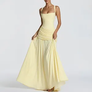 Detail of elegant pale yellow maxi dress featuring pleated waist and flowing wide skirt