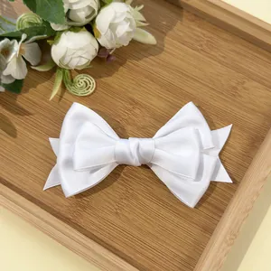 Close-up of white multi-layer bow hair clip on a bamboo tray with floral accents