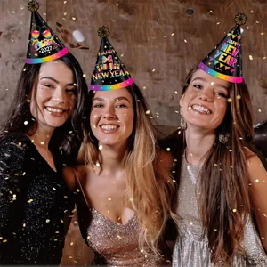 Three women wearing decorative paper New Year 2027 party hats with gold glitter pom poms