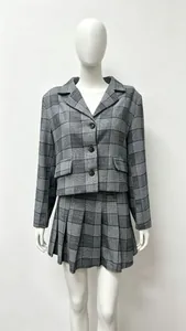 Detail view of the gray plaid fabric texture on a short blazer and pleated skirt set