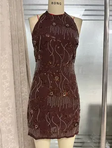 Détail des paillettes bordeaux et de la broderie de fleurs 3D sur une robe de fête