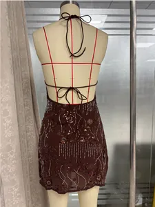 Détail de la mini robe à paillettes avec bretelles croisées et broderies perlées