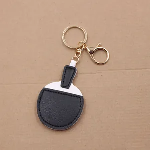 Detail of candy-colored leather table tennis racket keychain with gold metal hook