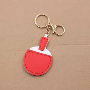 Detail of candy-colored leather table tennis racket keychain with golden metal clasp